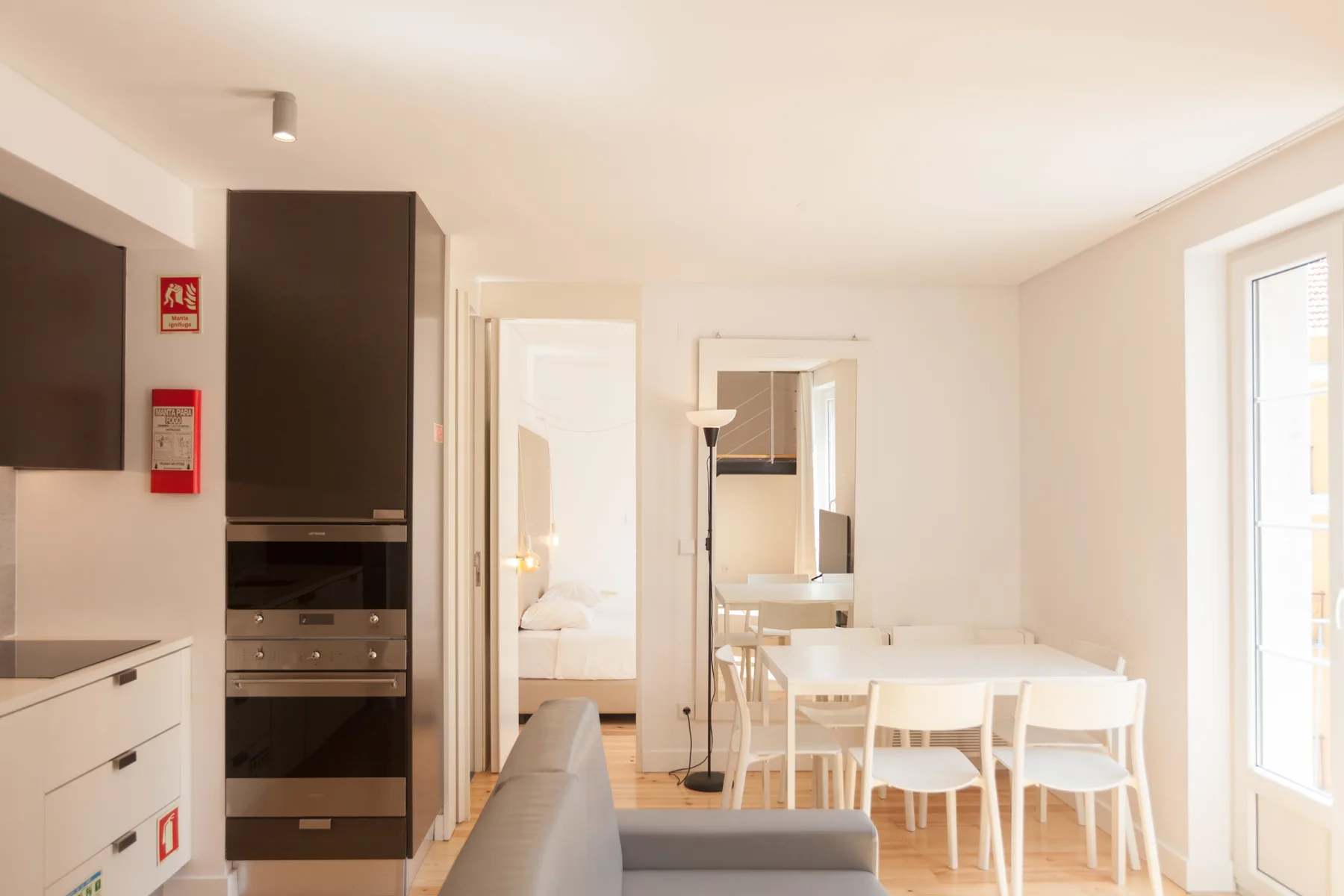 Una luminosa zona de comedor y estar con mesa, sillas y asientos.