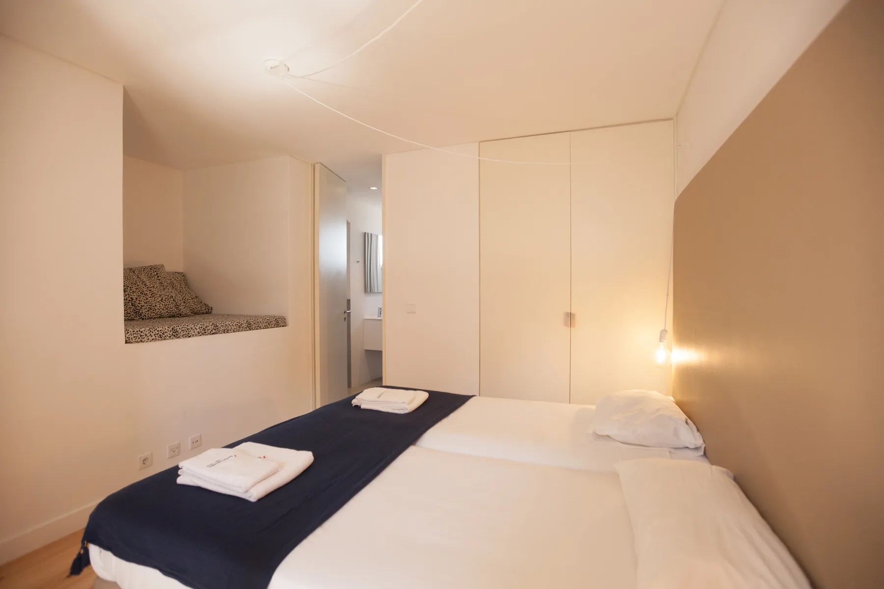 Un dormitorio con una cama bien hecha y armarios empotrados.