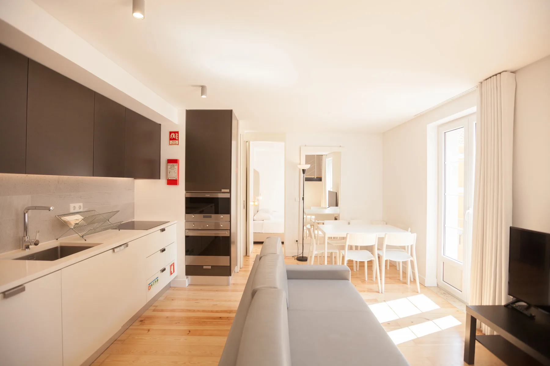 Una luminosa cocina abierta al salón, con una mesa de comedor junto a la ventana.