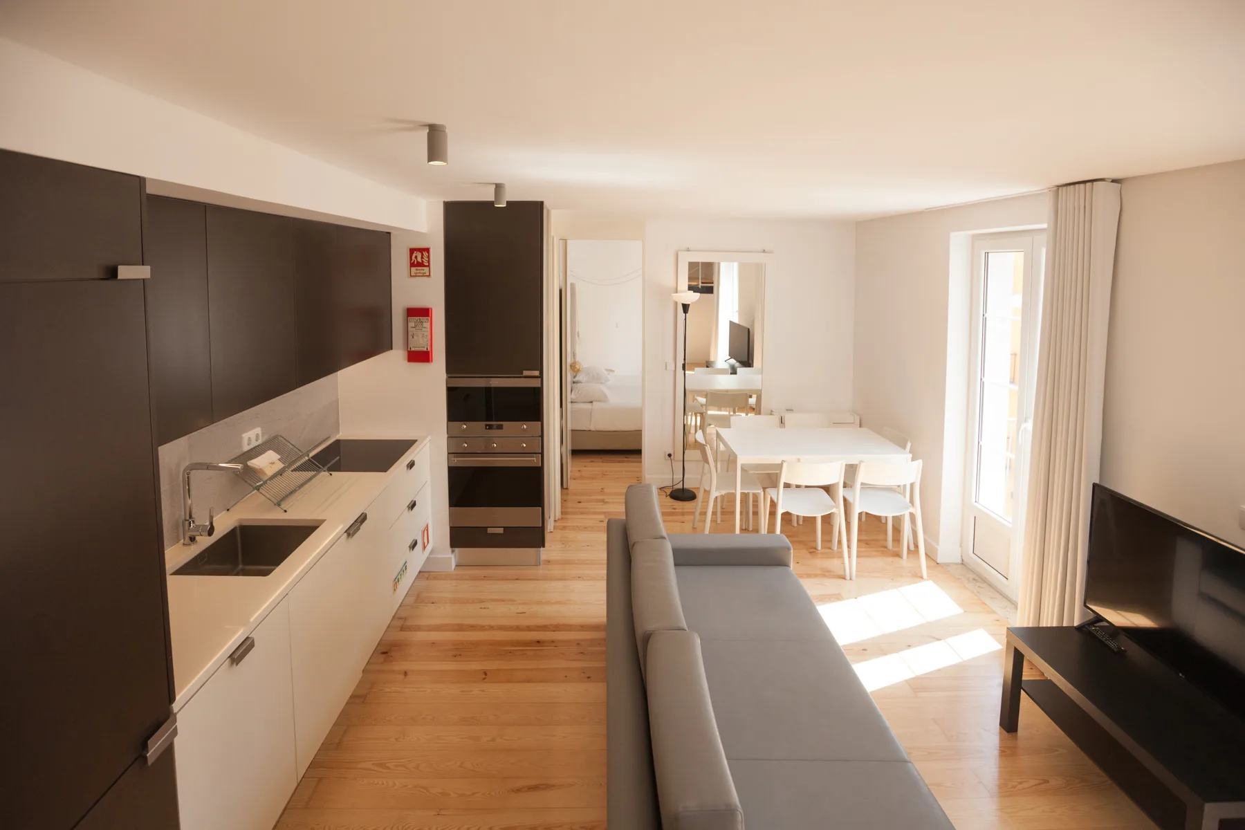 Una sala de estar diáfana con cocina, mesa de comedor y asientos.