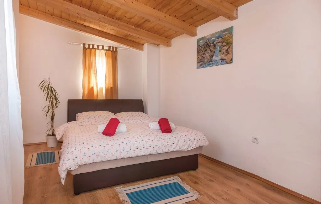 Un dormitorio con una cama doble, ropa de cama estampada y techo de madera.