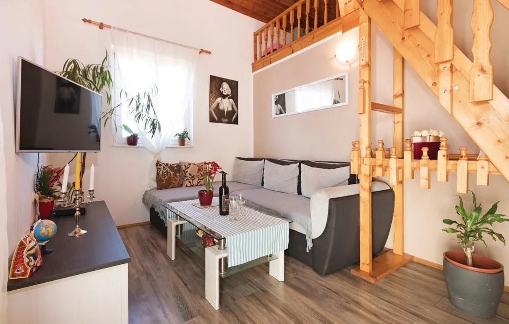 Una sala de estar con asientos, una mesa de centro y una escalera de madera.