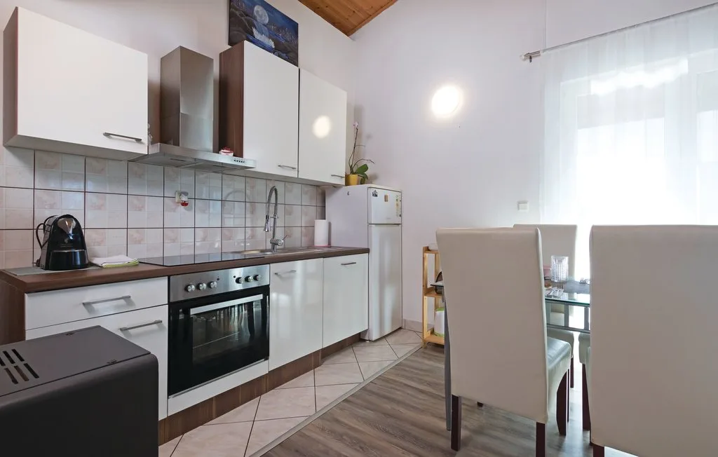 Una cocina compacta con un comedor junto a una ventana luminosa.