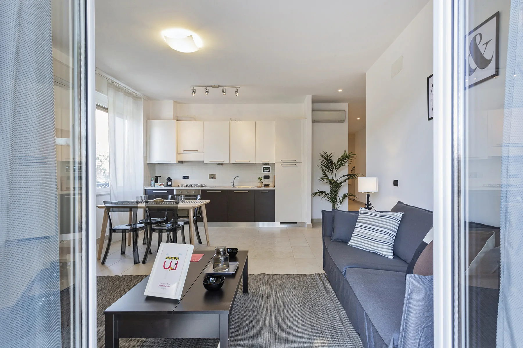Una sala luminosa con una zona de estar y una cocina abierta.