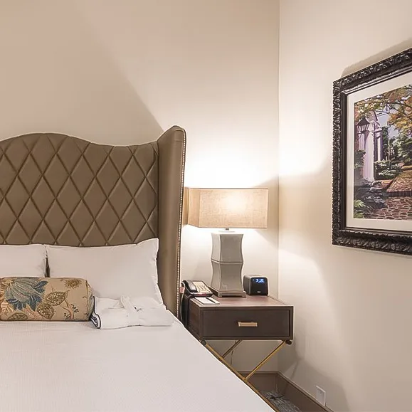 Guest room with bed, lamp and framed picture