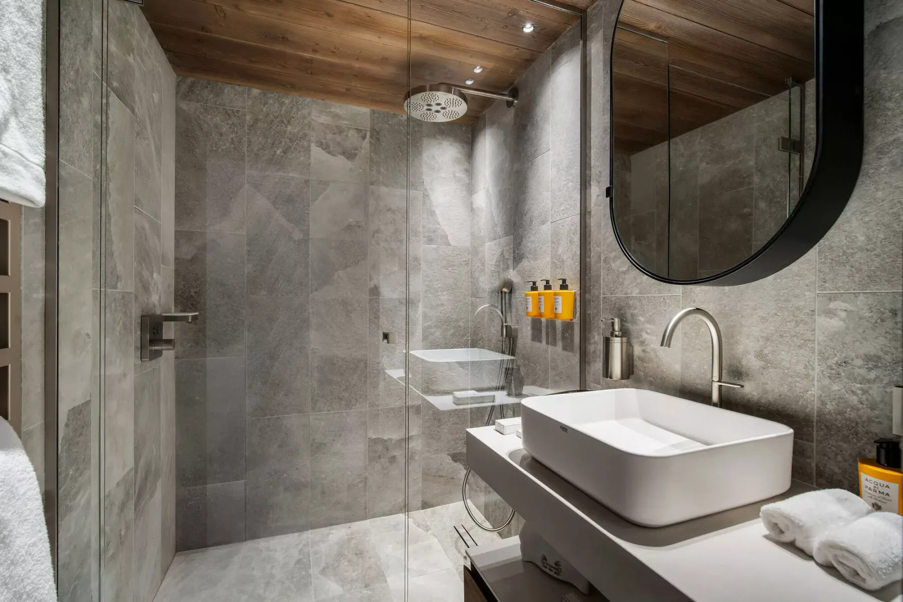 A modern bathroom with a glass shower and a vessel sink.