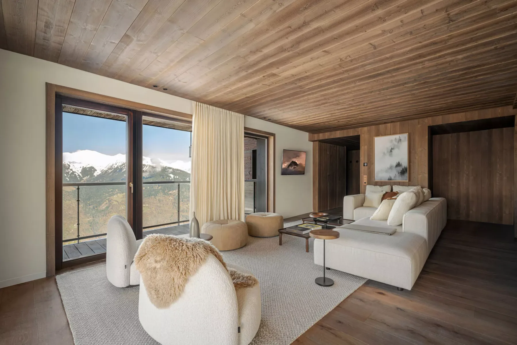 A living room with a seating area and large windows overlooking mountain scenery.