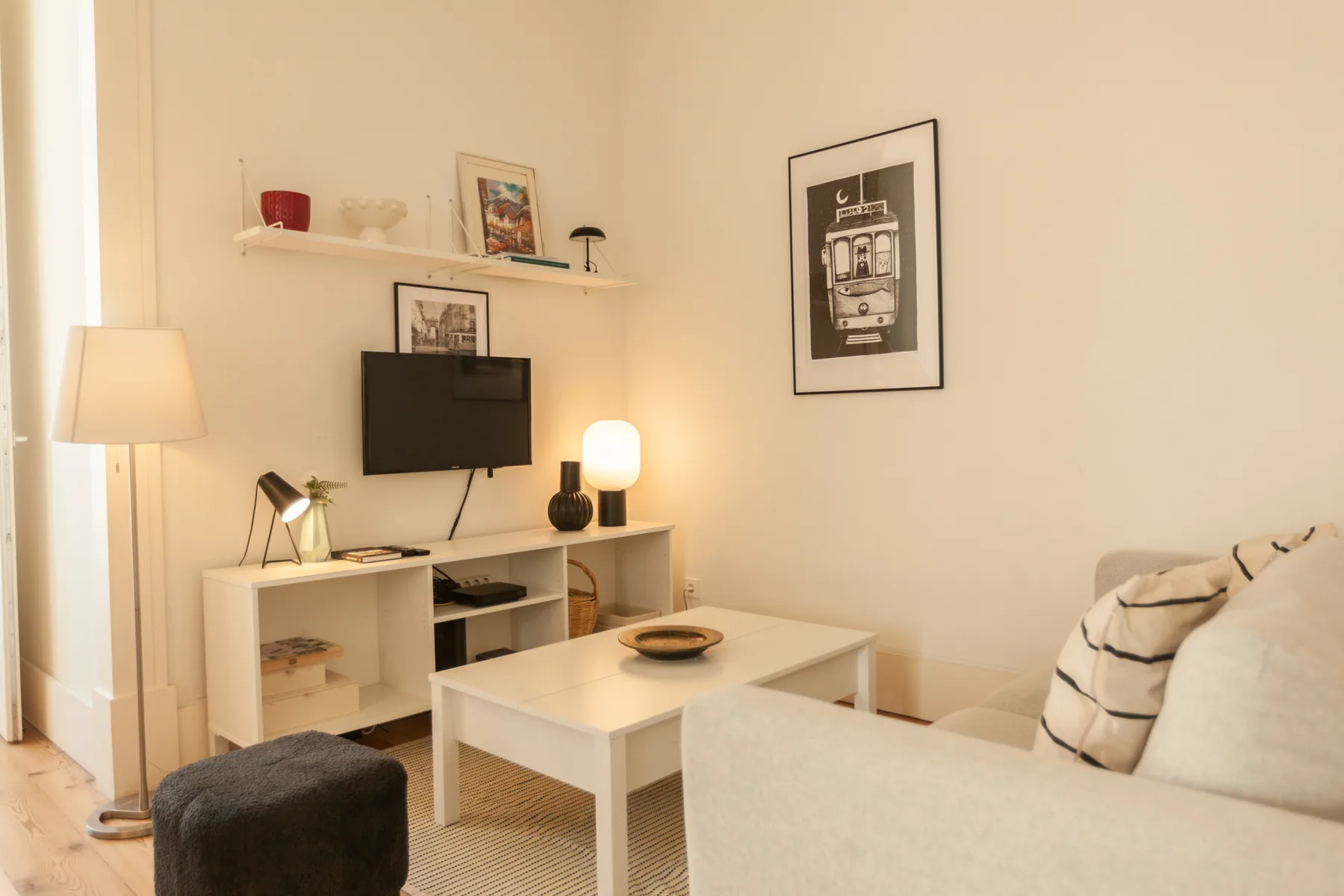 Sala de estar con televisor, mesa de centro y asientos.