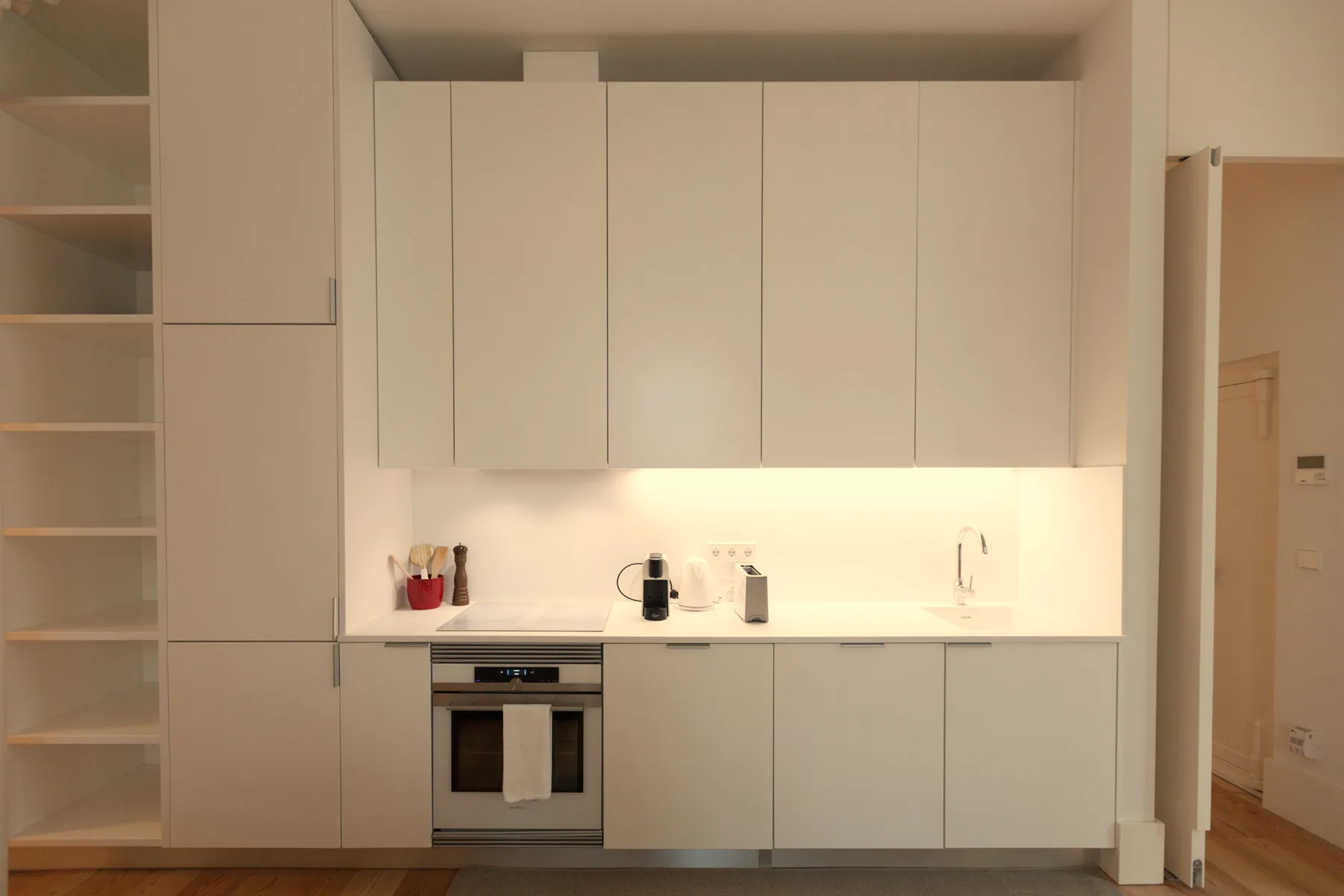 Una cocina moderna con gabinetes claros, una encimera y un horno.
