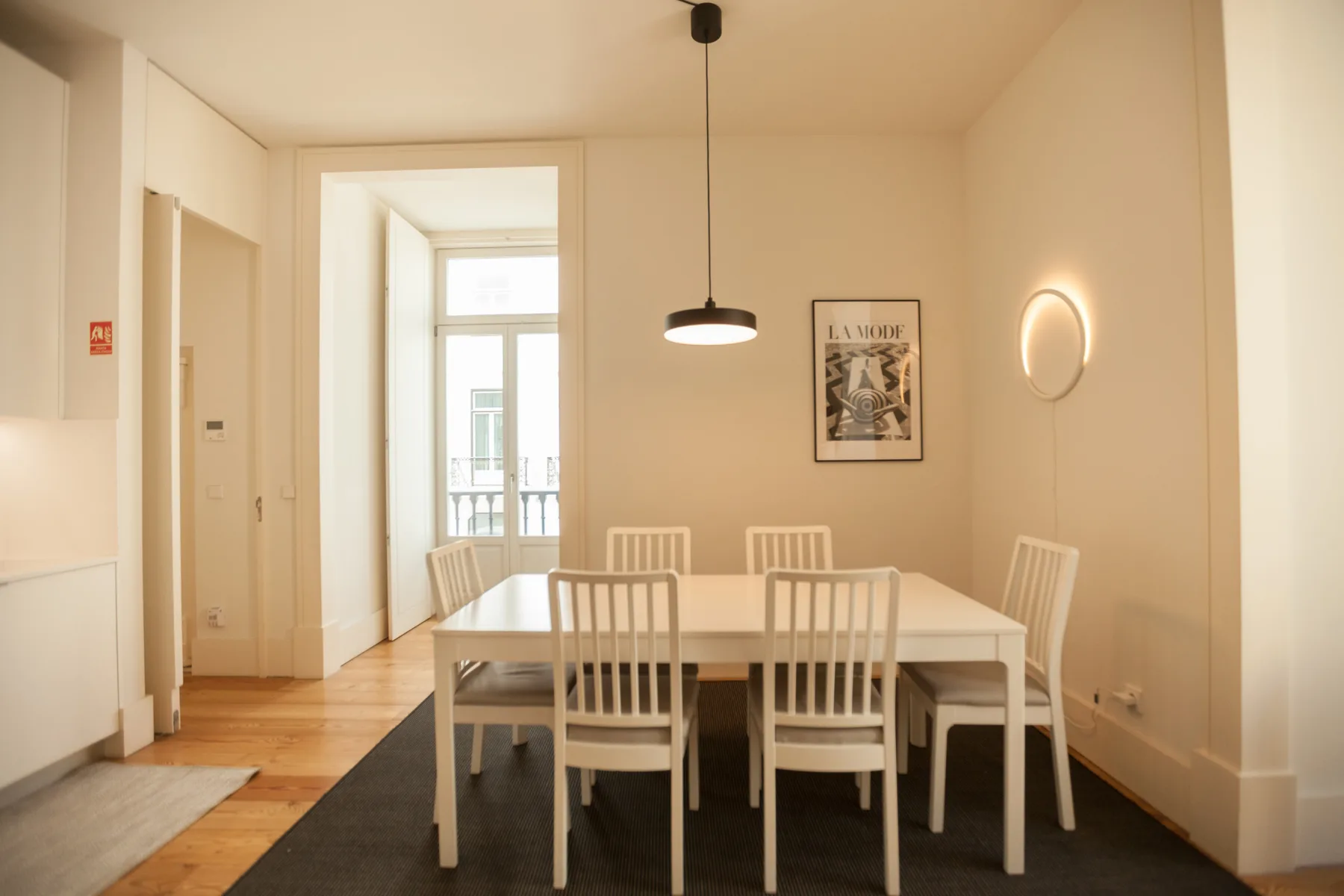 Comedor con una mesa rectangular, sillas y una lámpara colgante.