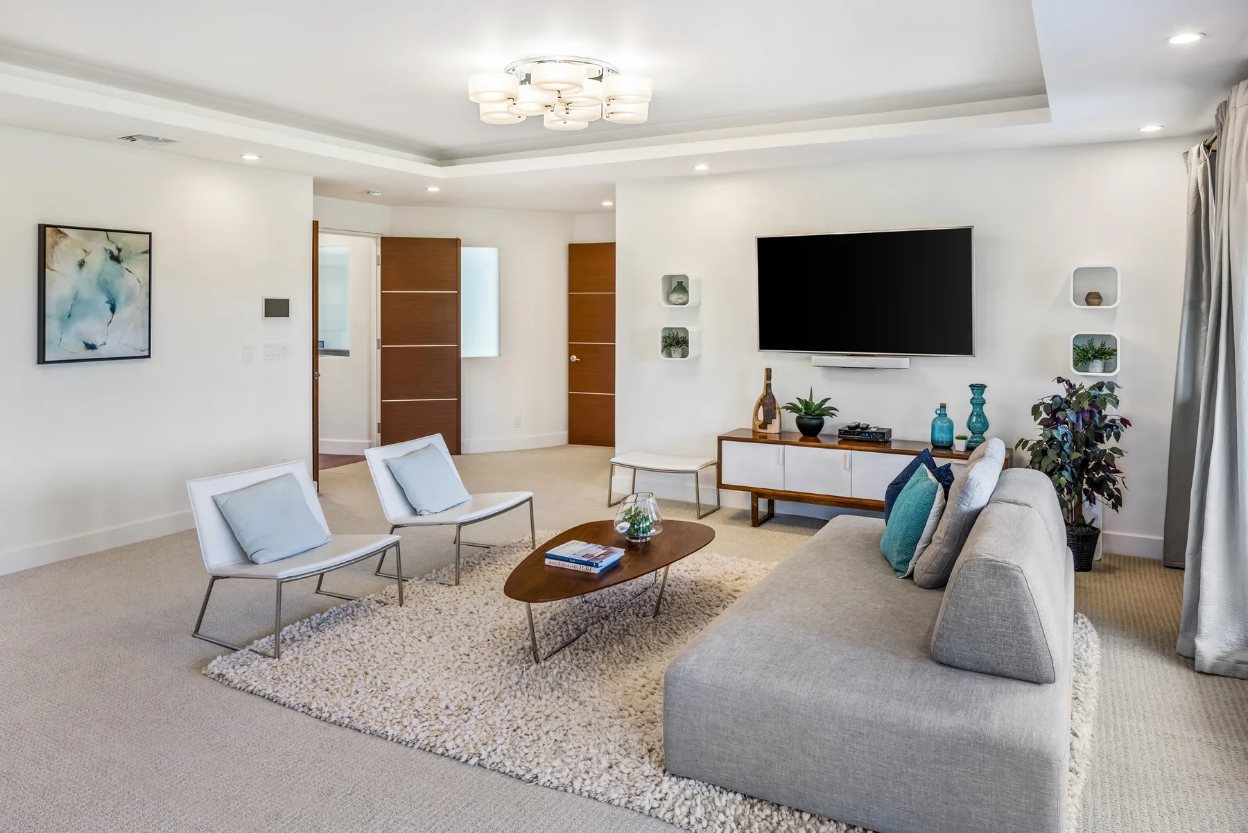 Una sala luminosa con asientos alrededor de una mesa de centro y un televisor.