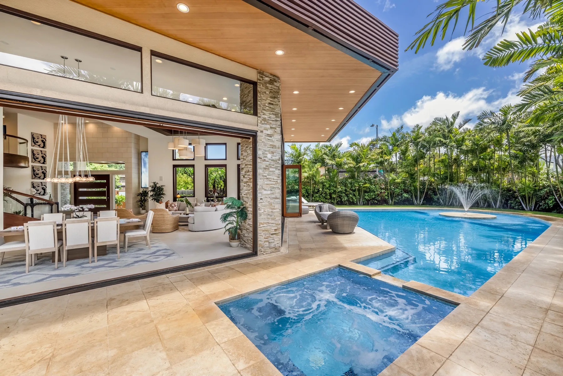 Una sala y comedor de estilo moderno se abren a una piscina y un patio.