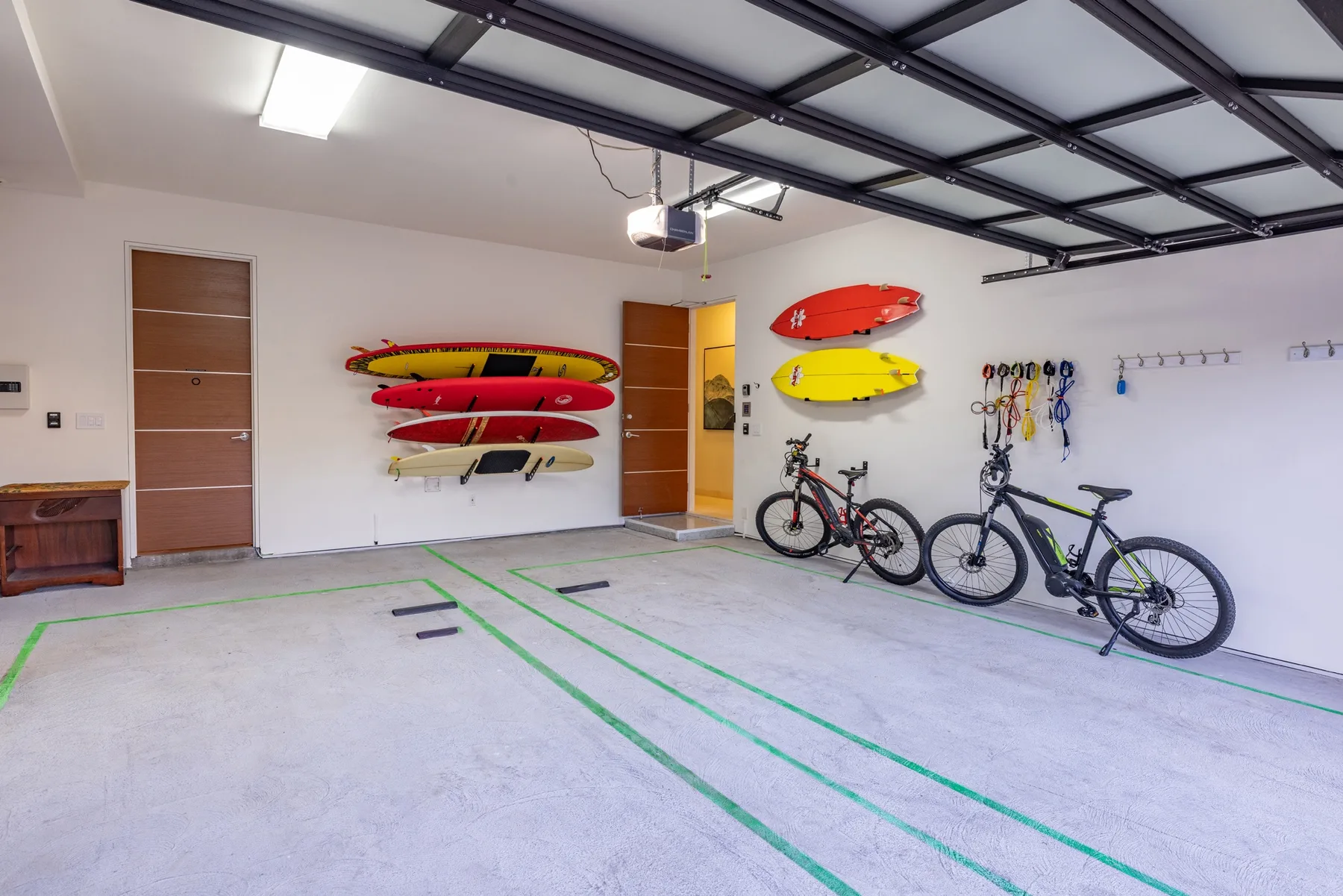 Un garaje con bicicletas y embarcaciones coloridas colgadas en la pared.