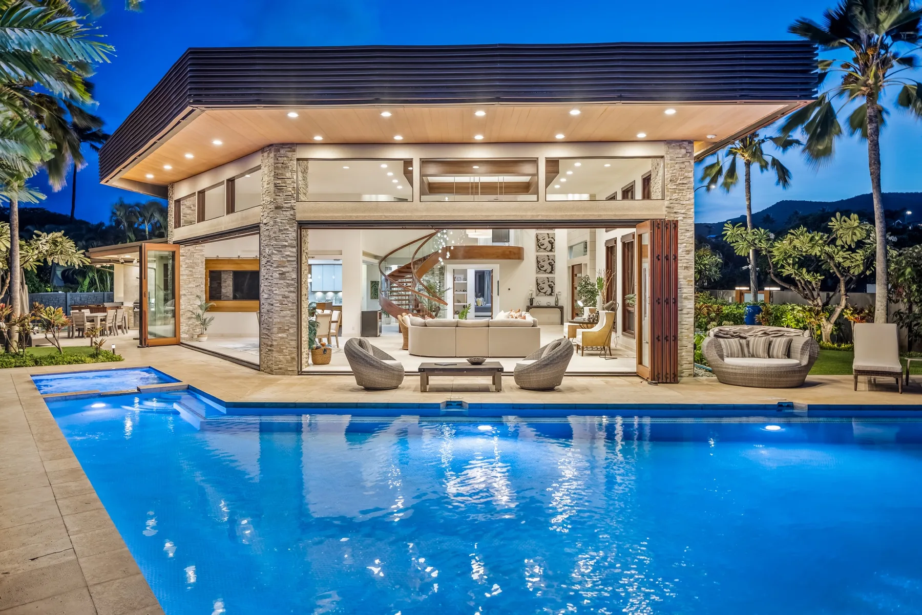 A modern house with a swimming pool, illuminated at dusk.