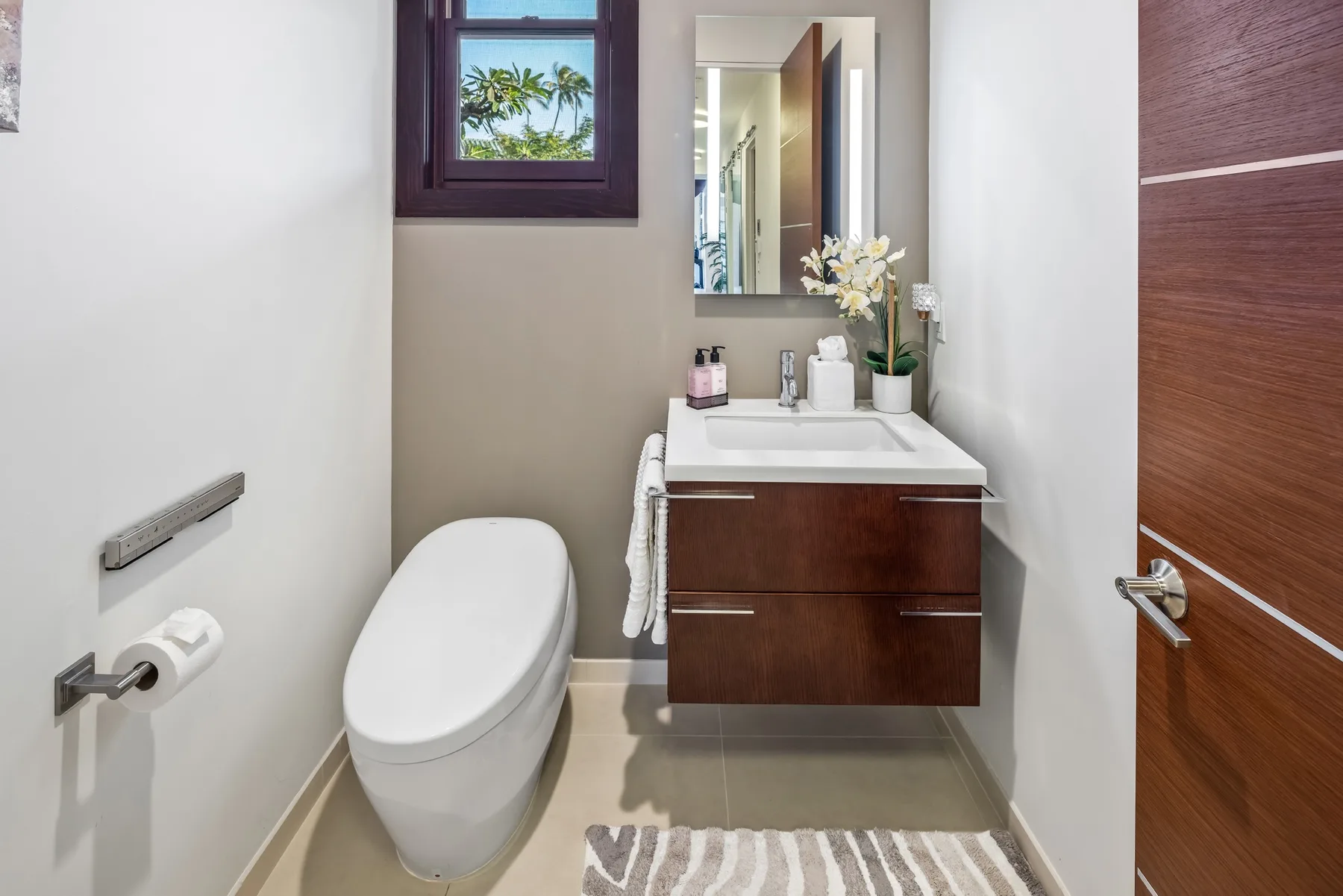 Un baño con inodoro, tocador y espejo.