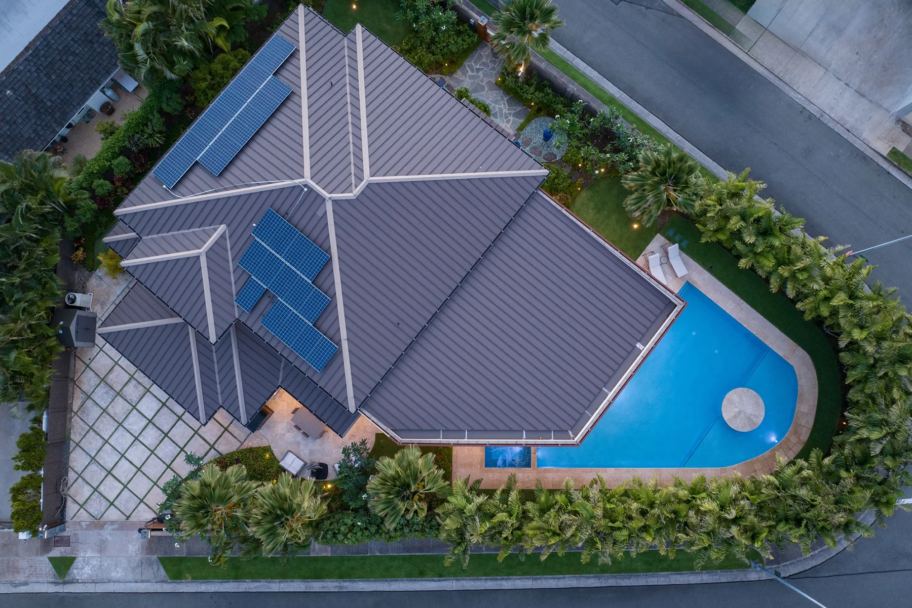 Vista aérea de una casa con piscina y jardines alrededor.