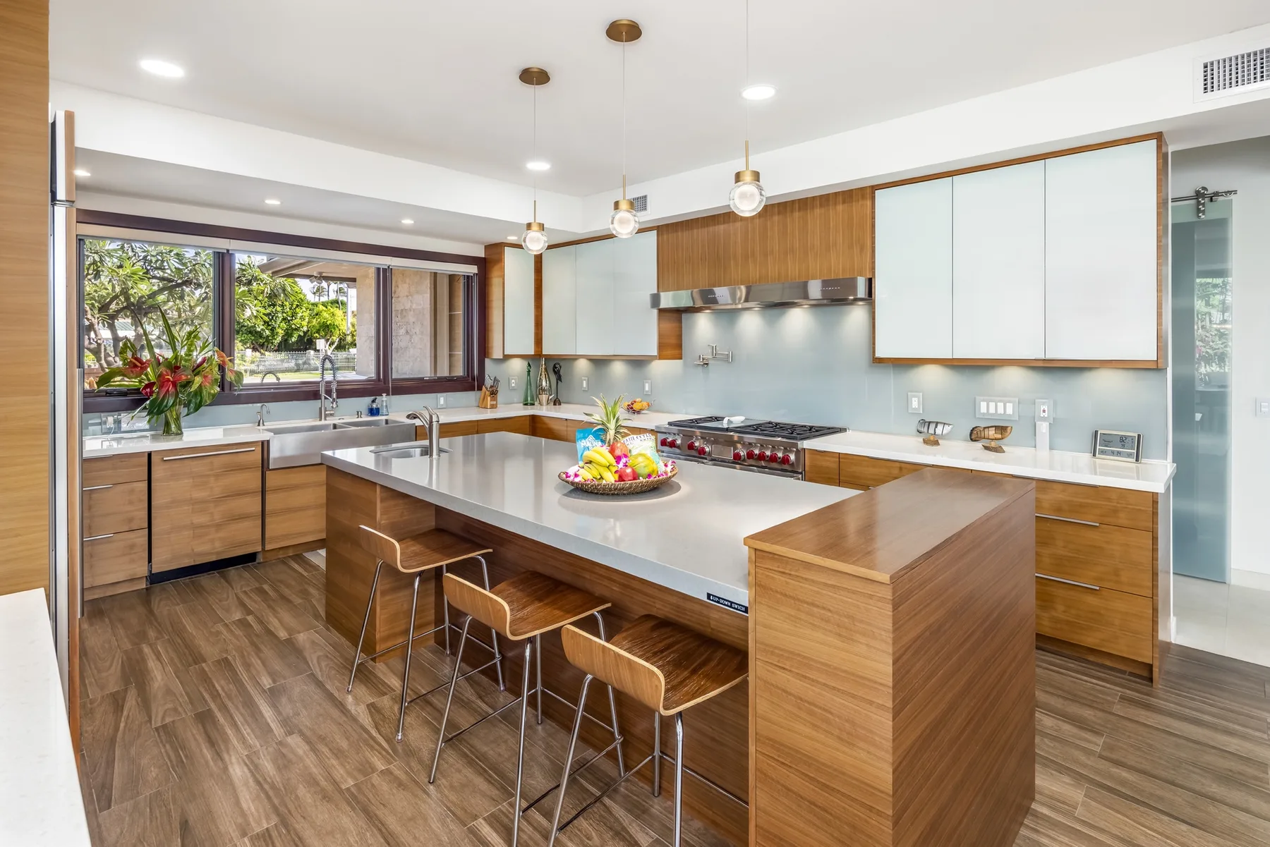 Una cocina moderna y luminosa con una gran isla y gabinetes de madera.