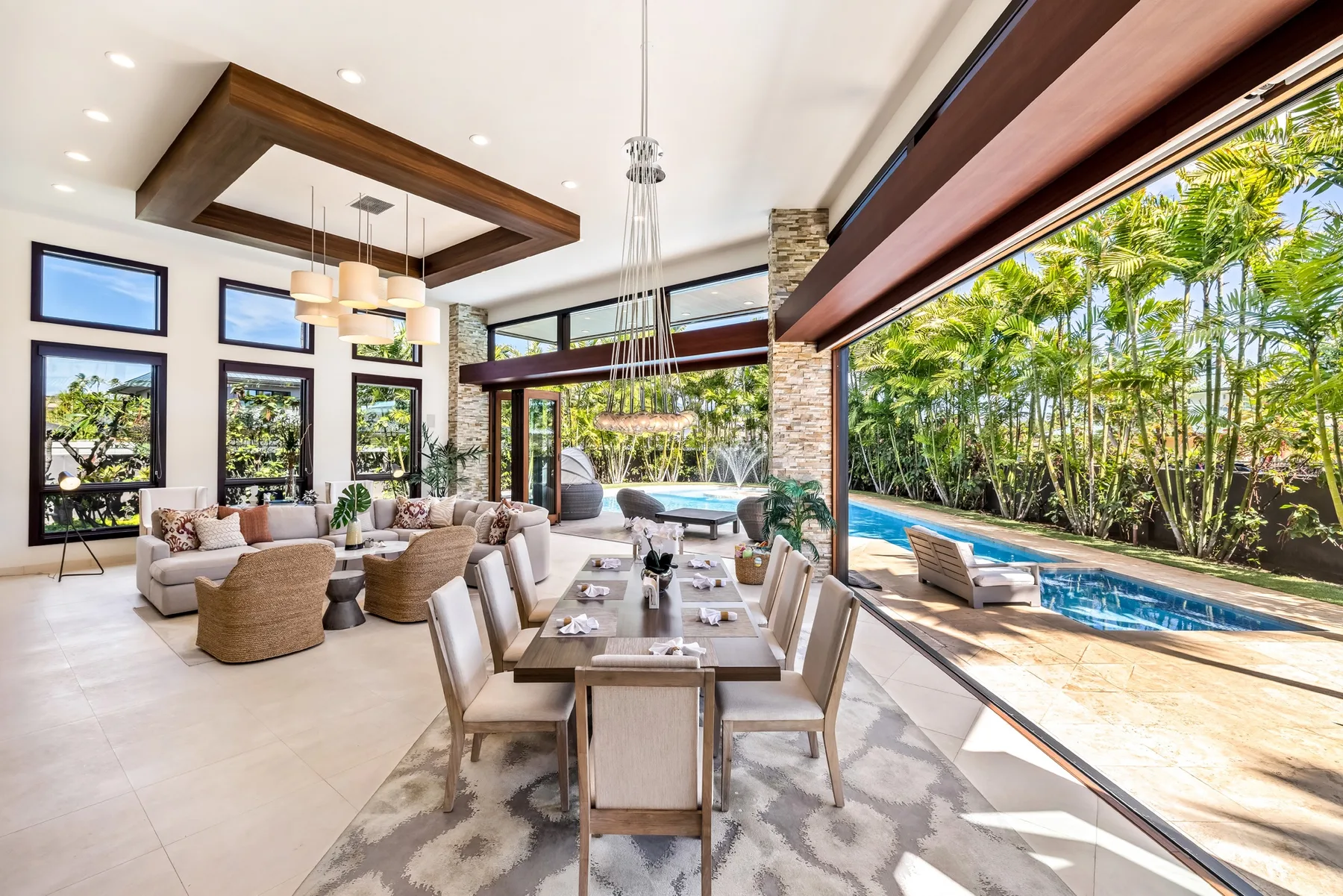 A bright open-plan living and dining area opens onto a poolside patio.