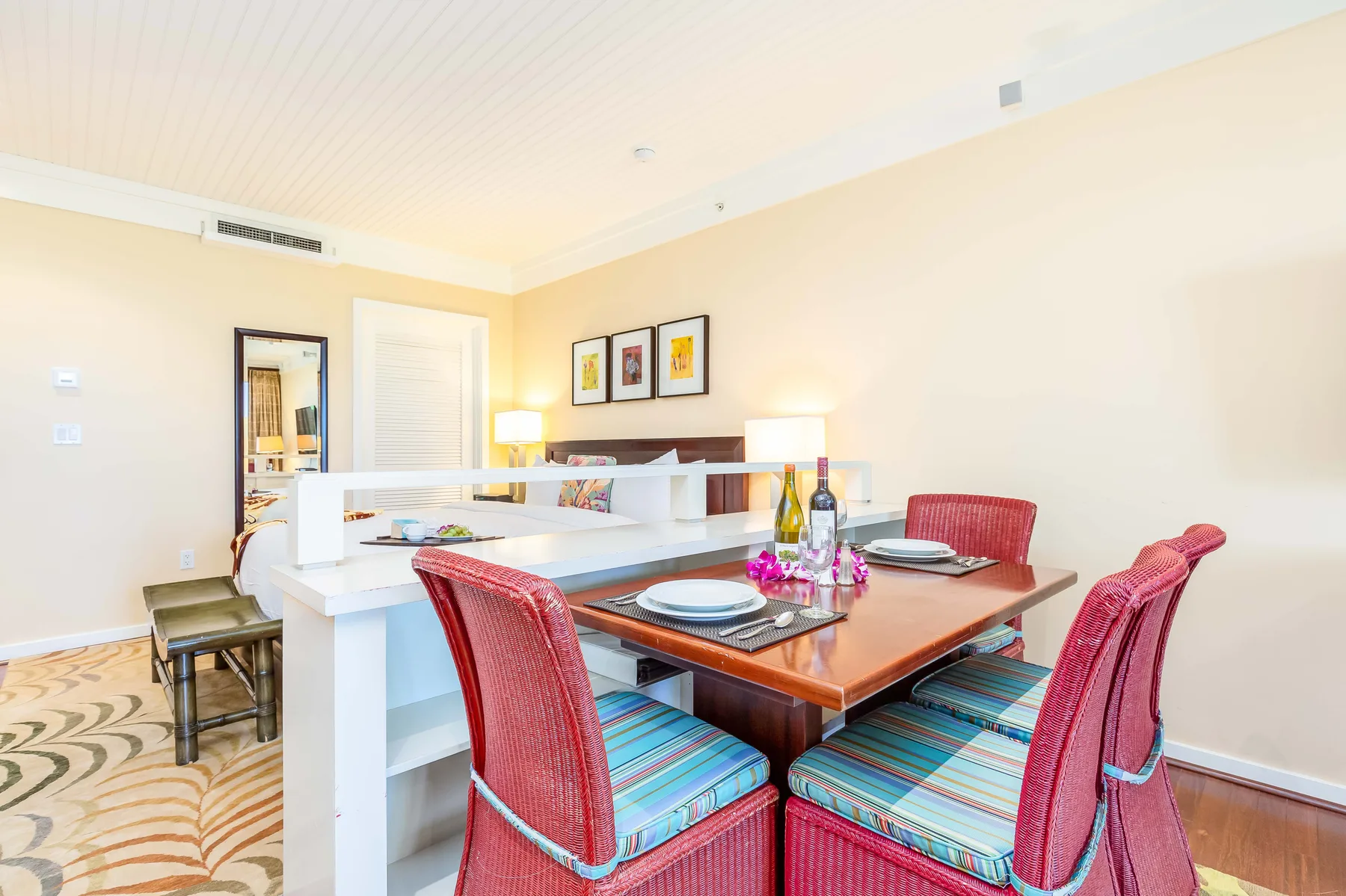A dining area with a wooden table, red seating, and a white counter.
