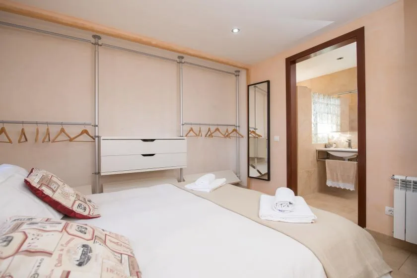 A bedroom with a bed and an open doorway to a bathroom.