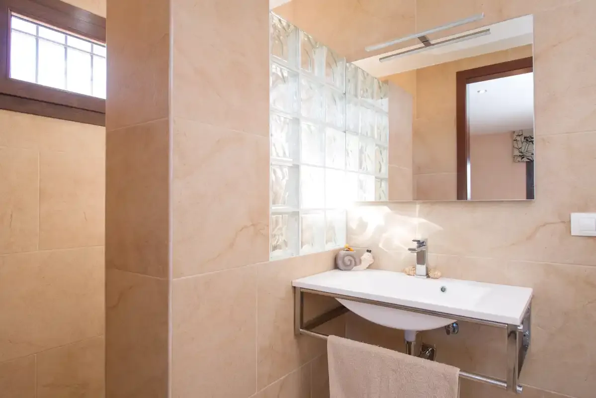 A bathroom with a sink beneath a large mirror.