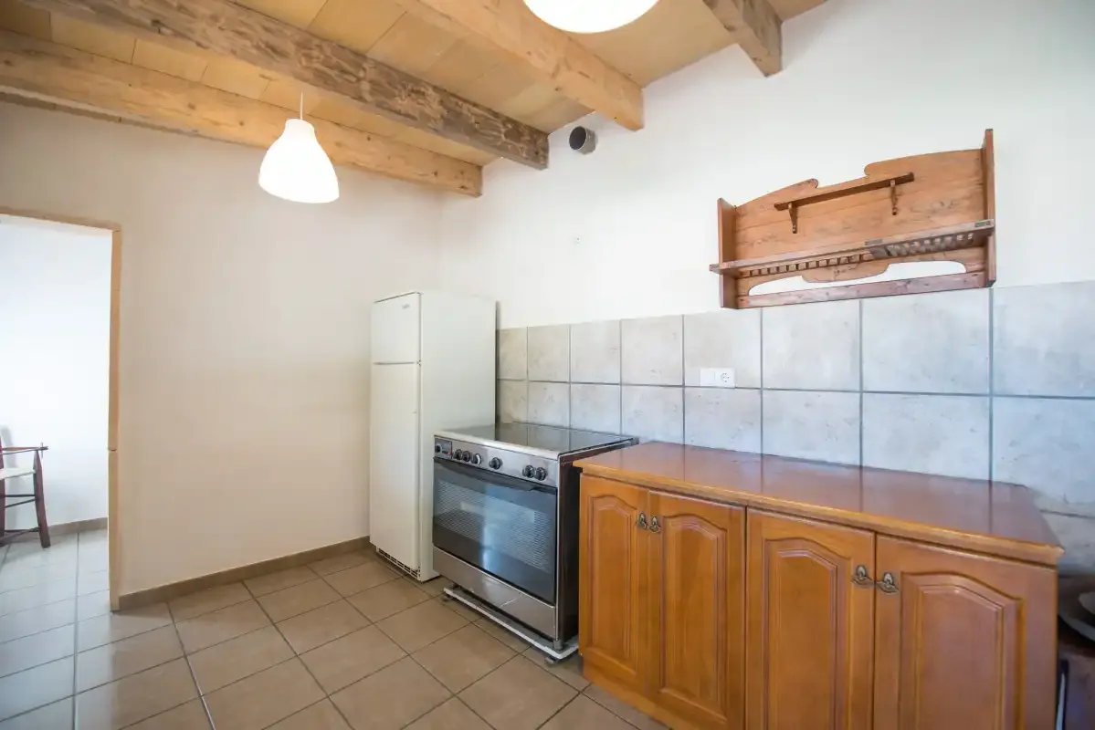 A kitchen with wooden cabinets, a refrigerator, and a stove.