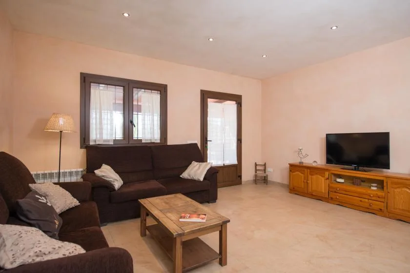 A living room with seating, a coffee table, and a television.