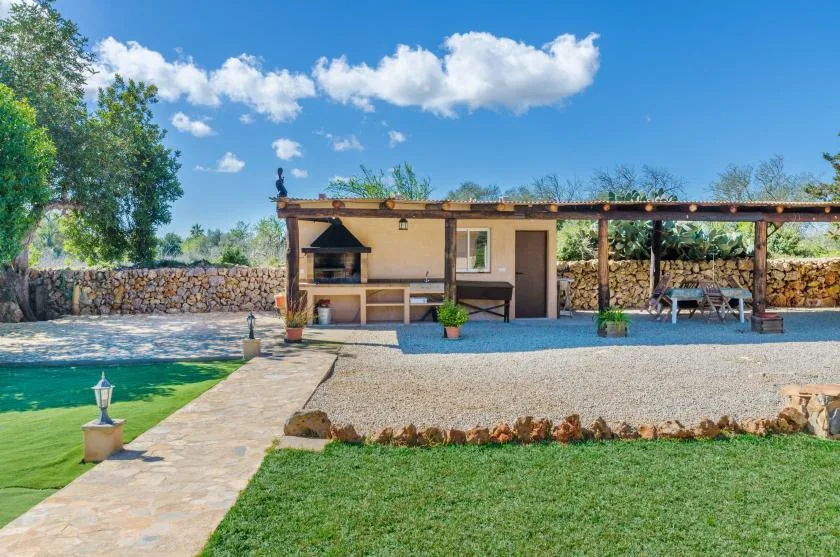 An outdoor patio with a built-in barbecue, seating, and a swimming pool nearby.