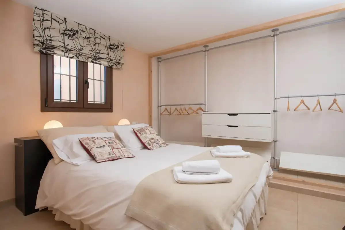 A bedroom with a double bed and a built-in clothes storage area.