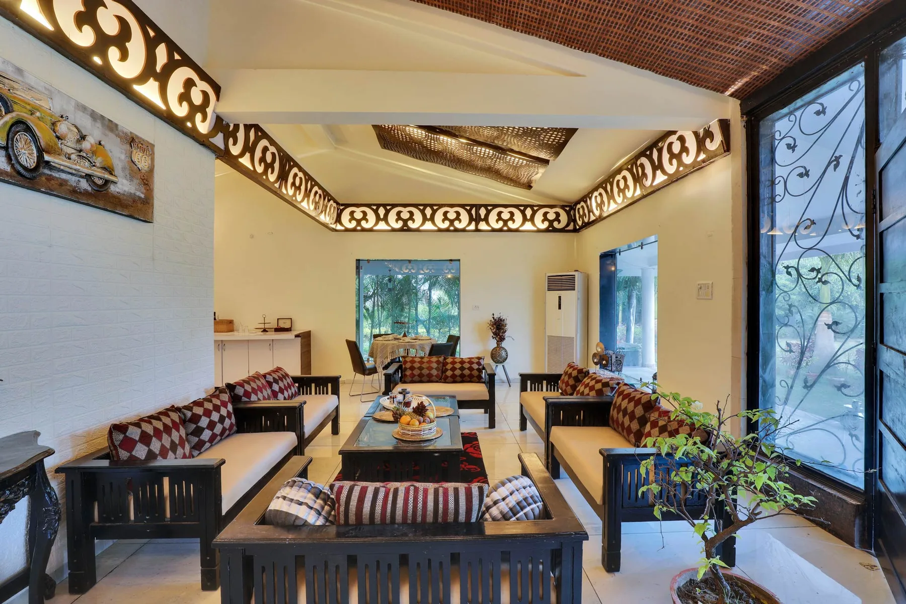 A bright lounge with wooden seating arranged around a low central table.