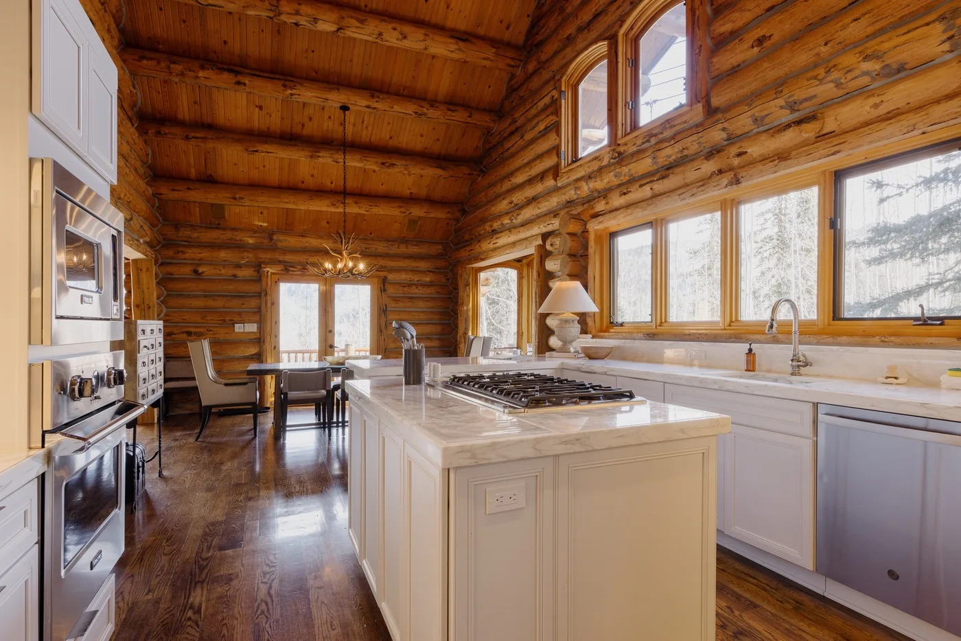 A wood-paneled kitchen with a central island and dining area.