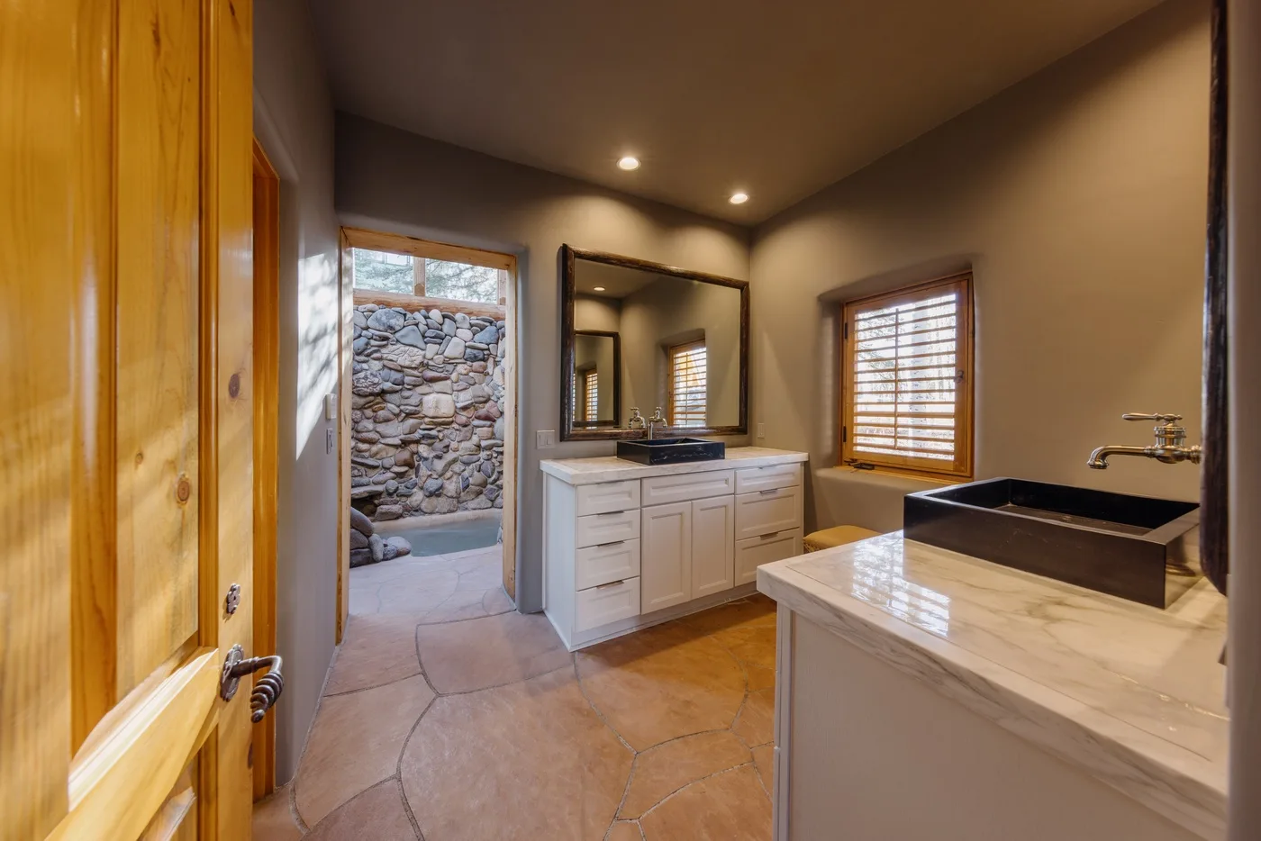 A bathroom with a vanity, mirror, and a large sink in the foreground.