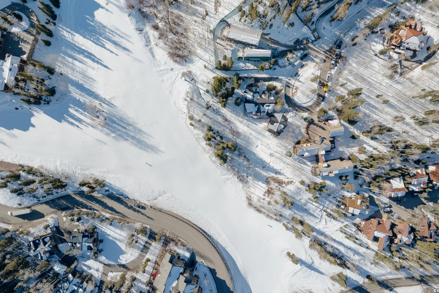 An aerial view shows a snow-covered landscape with scattered buildings and roads.