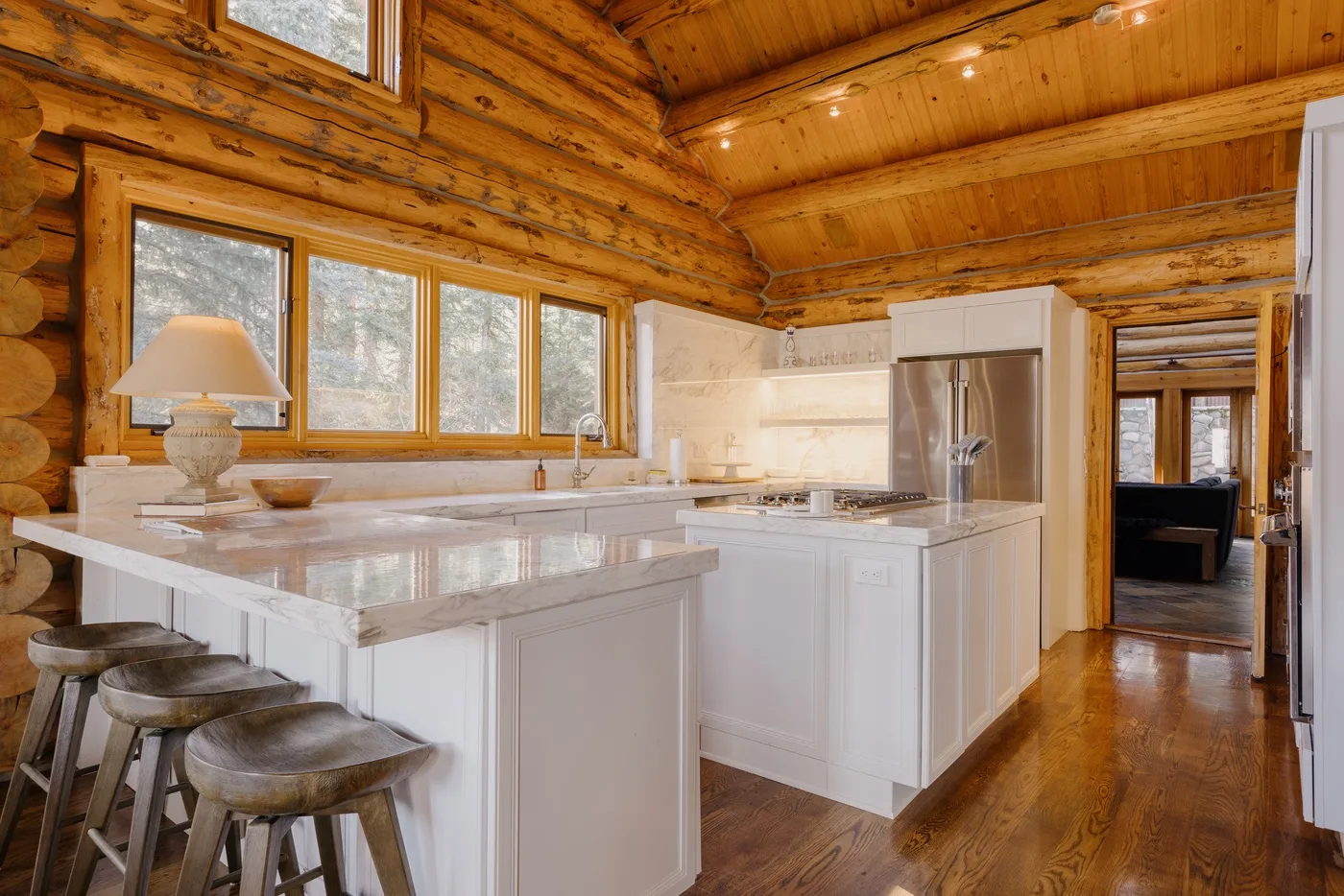 A wood-paneled kitchen features white cabinetry and a central island.