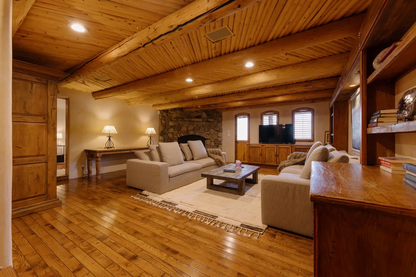 A wood-paneled living room with sofas arranged around a central coffee table.