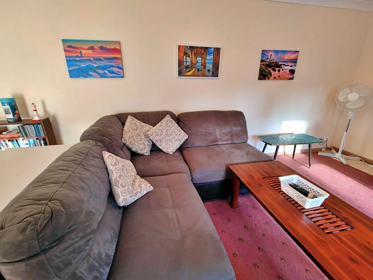 A living room with a large sectional sofa and a wooden coffee table.