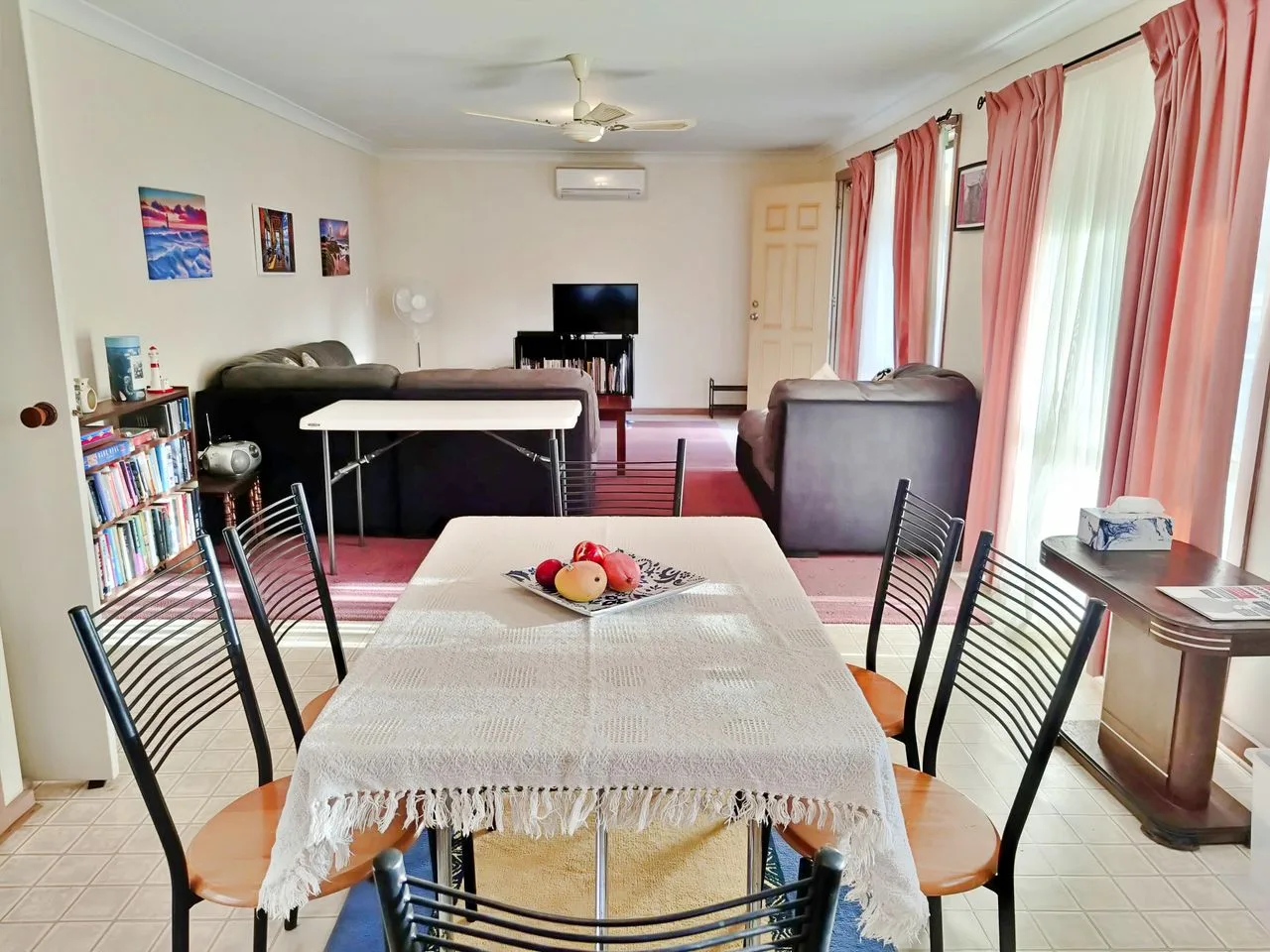 A living and dining room with a table in the foreground and seating beyond.