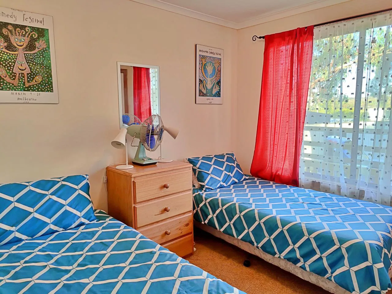 A bedroom with two beds dressed in blue patterned bedding.