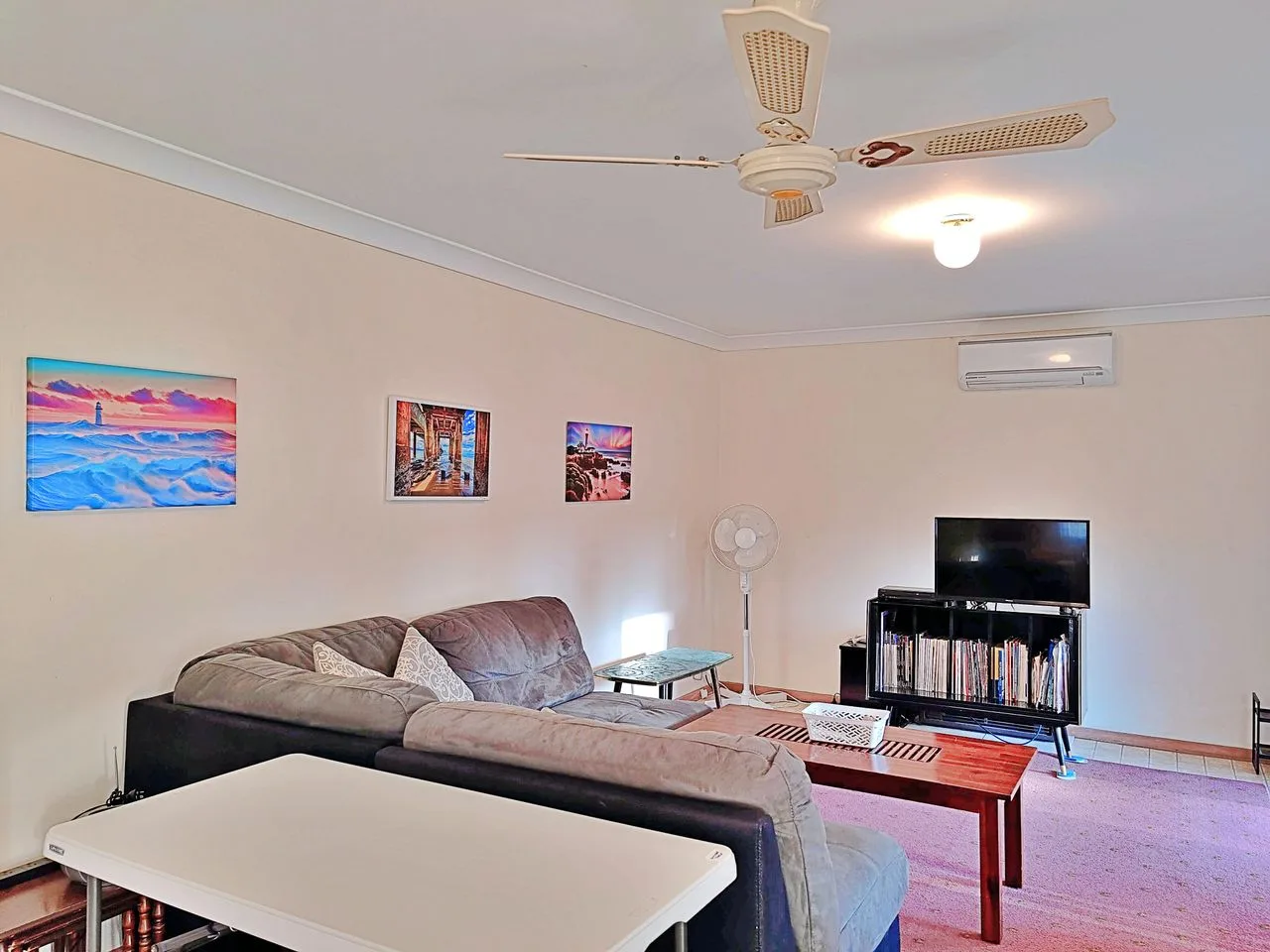 A living room with sectional seating, a coffee table, and a television.