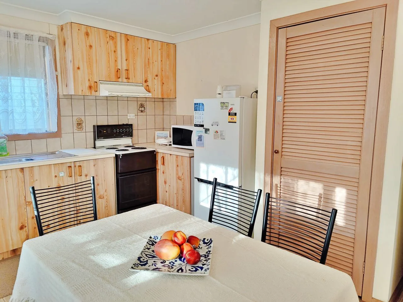 A kitchen and dining area with wood cabinetry and a table.
