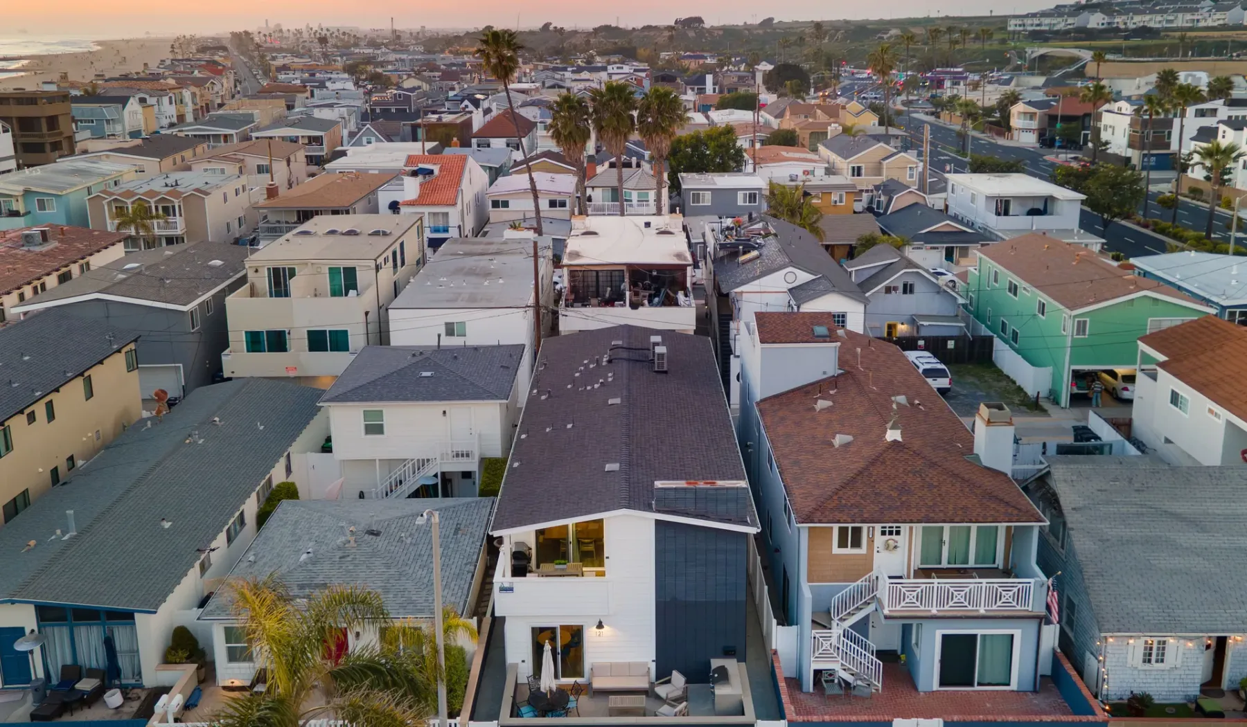Vista aérea de un barrio costero densamente construido, con hileras de viviendas.