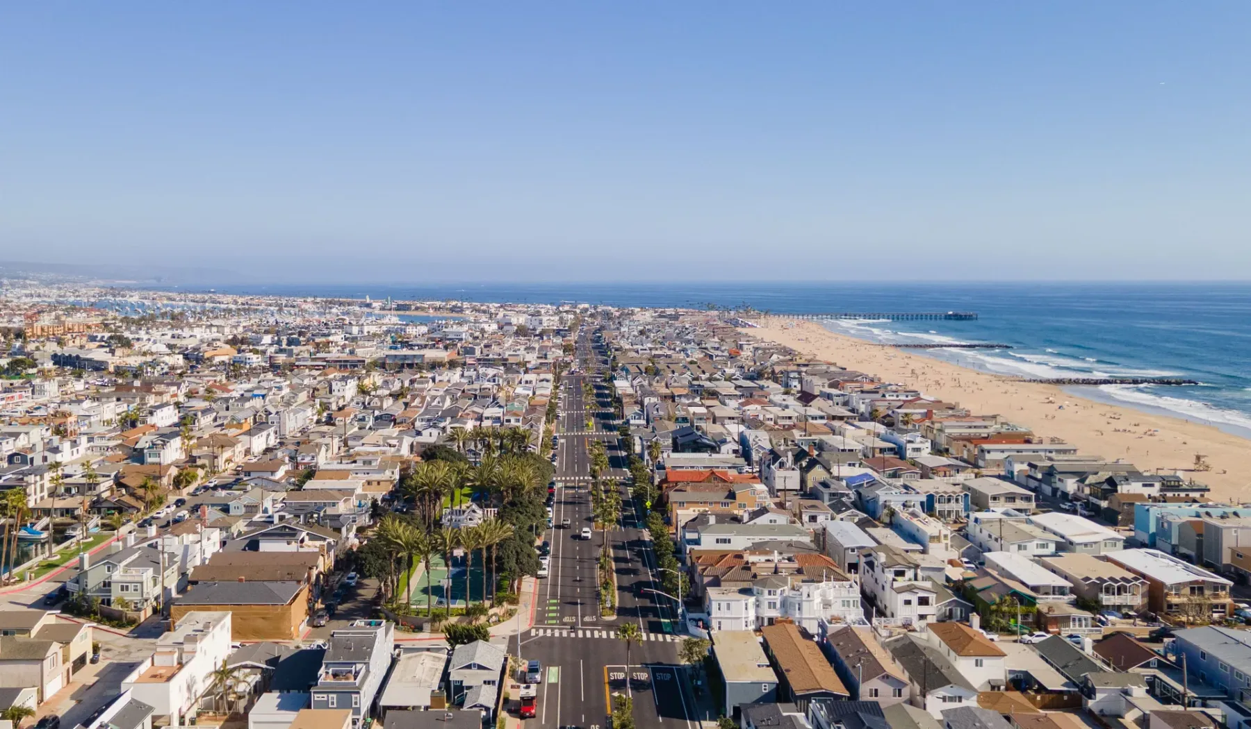 Vista aérea de una ciudad costera con una larga playa y el océano junto al pueblo.