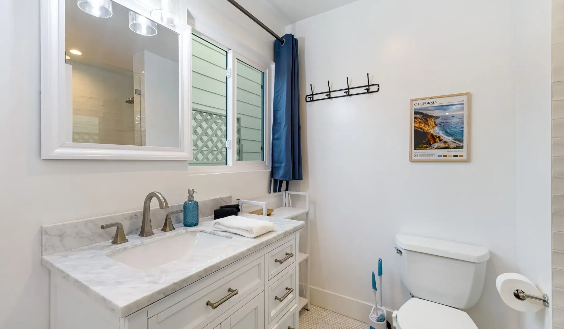 Un baño luminoso con lavabo, espejo e inodoro.