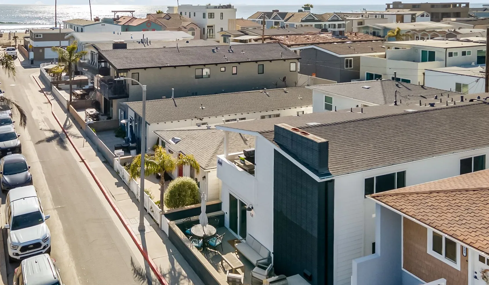 Vista aérea de edificios residenciales muy próximos junto a una calle cerca de la costa.