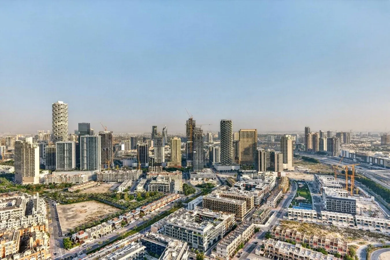 Una amplia vista urbana de edificios modernos y carreteras bajo un cielo despejado.