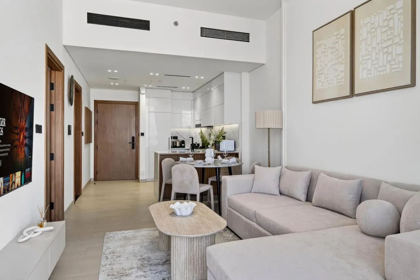 Una sala luminosa con asientos, una mesa de centro y un comedor al fondo.
