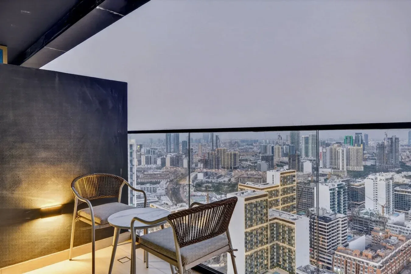 Una zona de estar en el balcón ofrece vistas a un denso paisaje urbano.