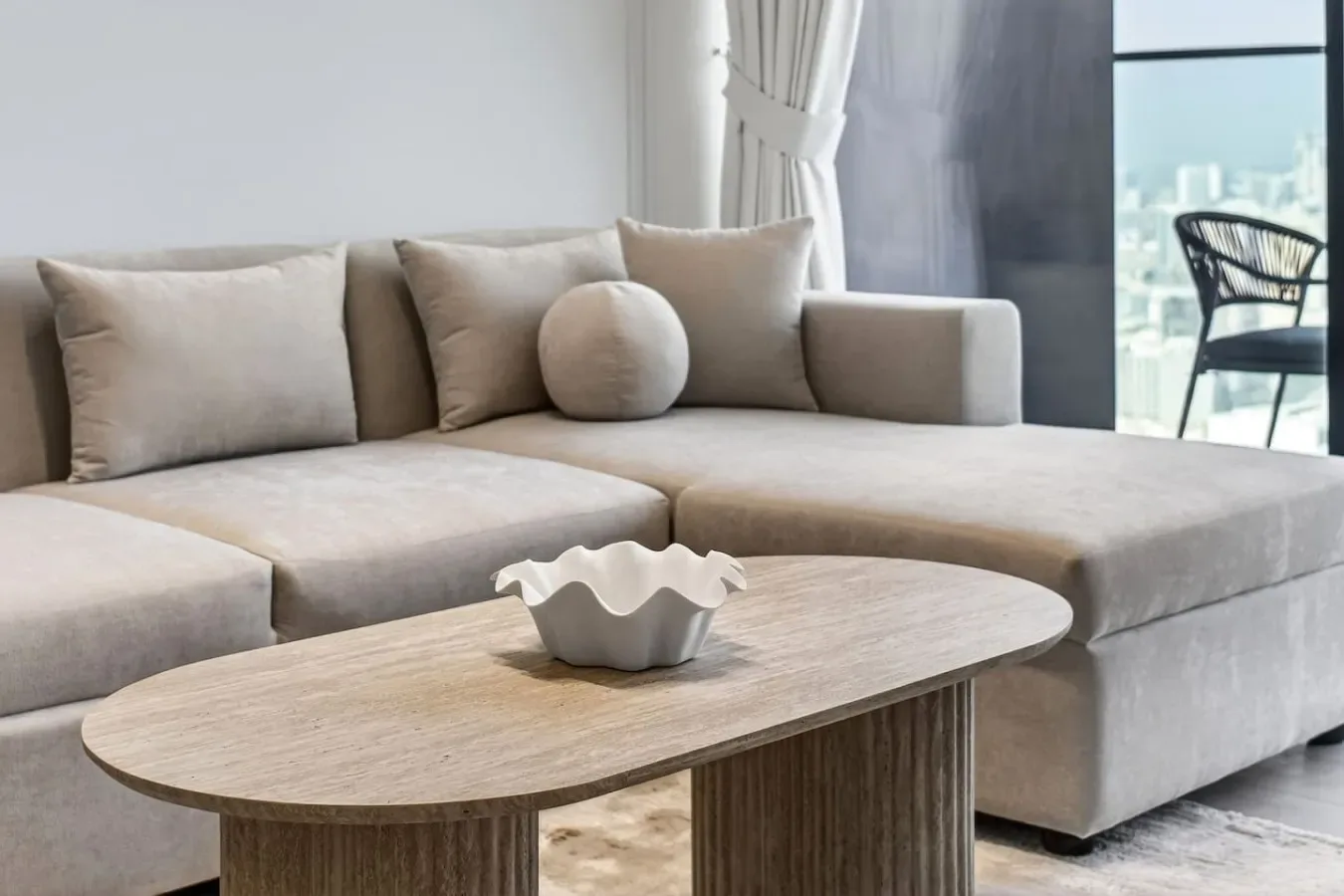 Una sala luminosa con un sofá seccional y una mesa de centro baja.