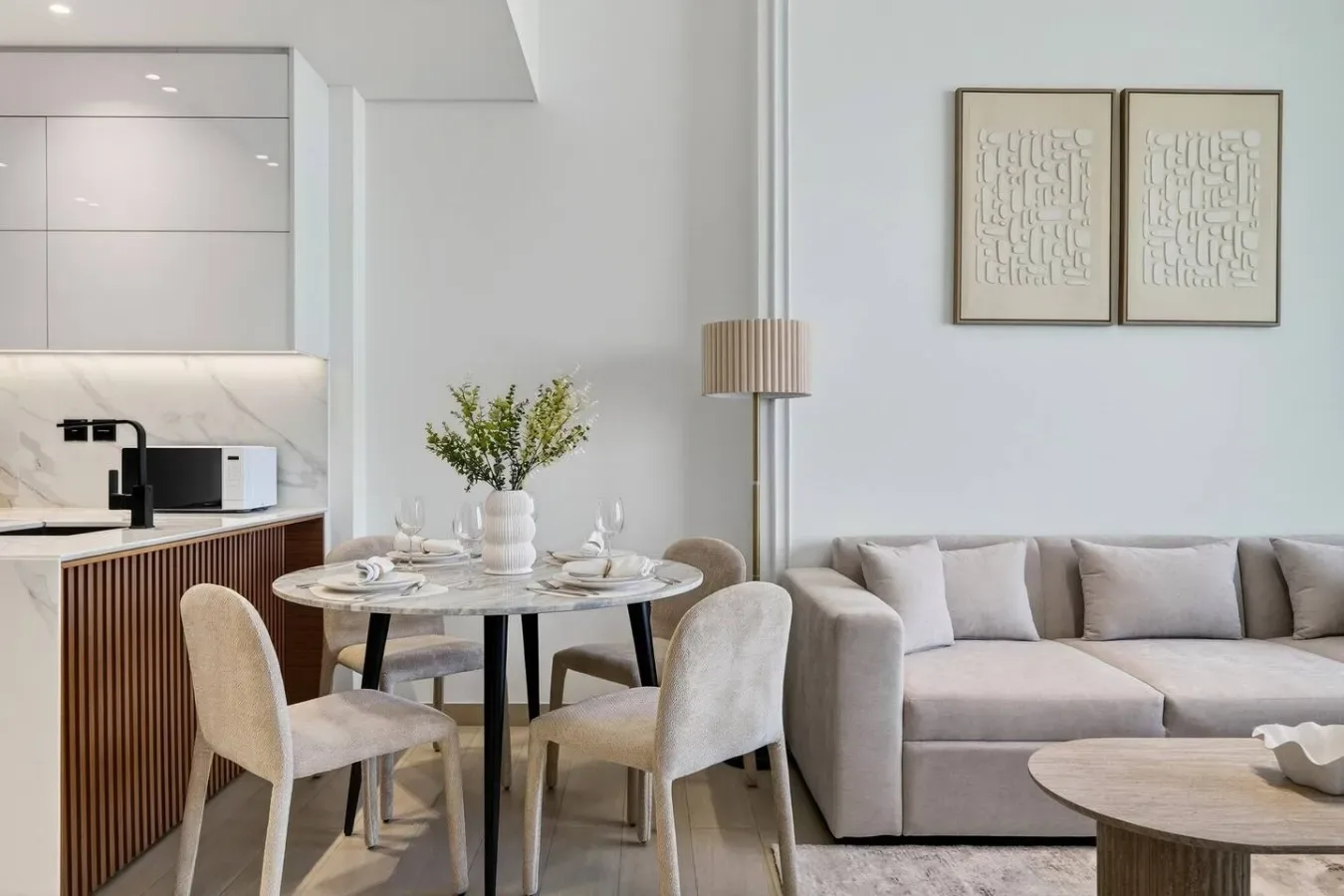 Una sala de estar y comedor modernos con sofá, mesa de comedor y cocina abierta.