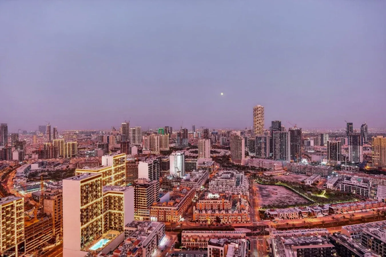 Un horizonte urbano al anochecer, con numerosos edificios bajo un cielo claro.